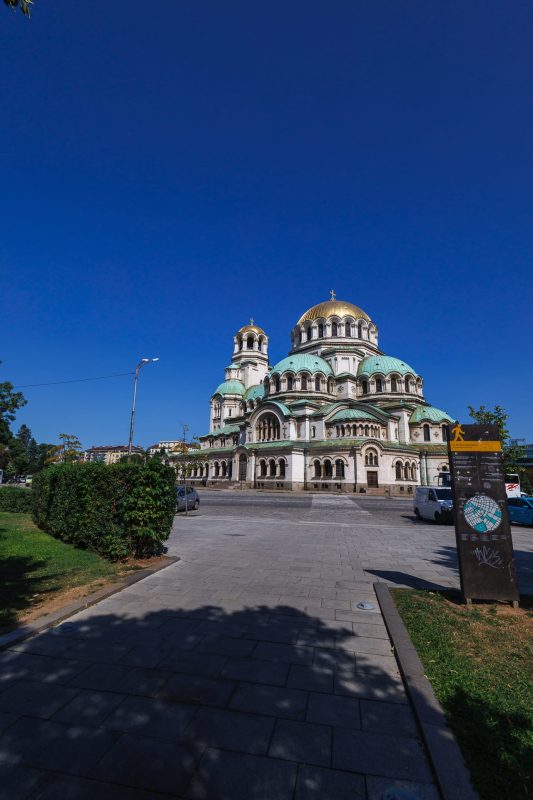 Alexander Nevsky Cathedral with distinctive golden domes and green copper roof against blue sky in Sofia, Bulgaria