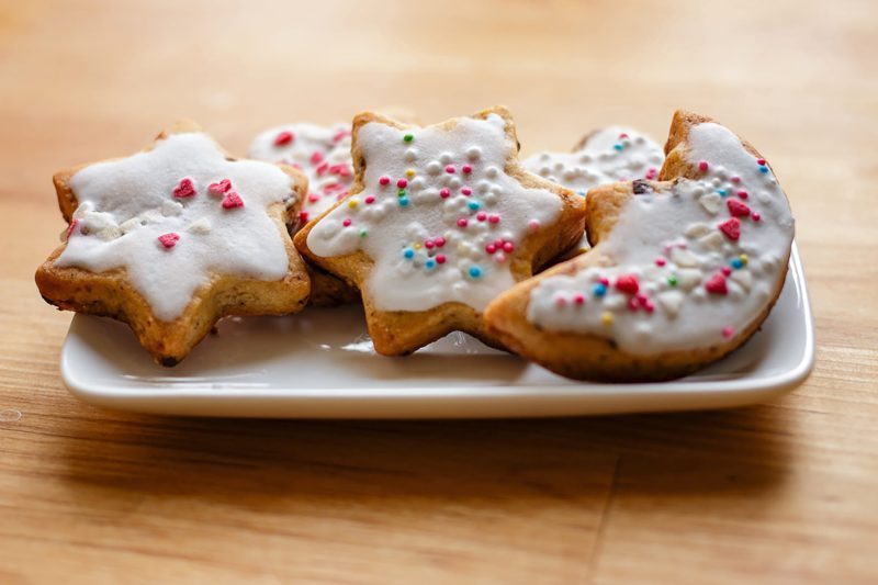 Homemade Christmas cookies with white icing and colorful sprinkles