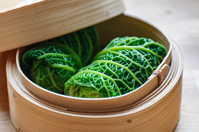 Stuffed savoy cabbage rolls in a bamboo steamer