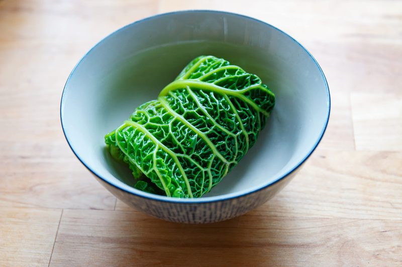 Stuffed savoy cabbage roll served in a ceramic bowl